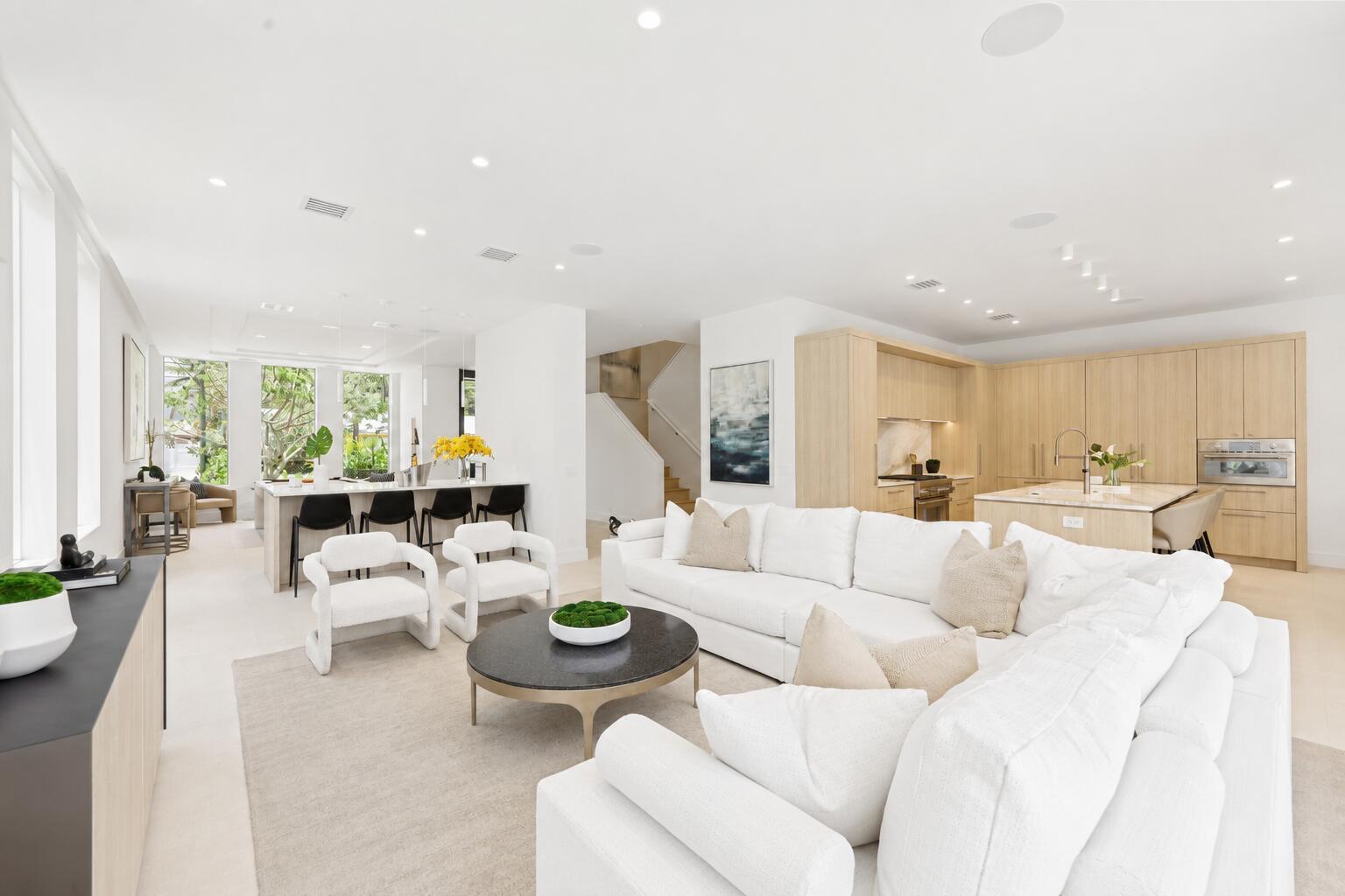 A bright, open-concept living room and kitchen featuring light wood cabinetry and white furniture — 519 SE 4th Avenue, Delray Beach FL 33483, DELRAY BEACH, FL