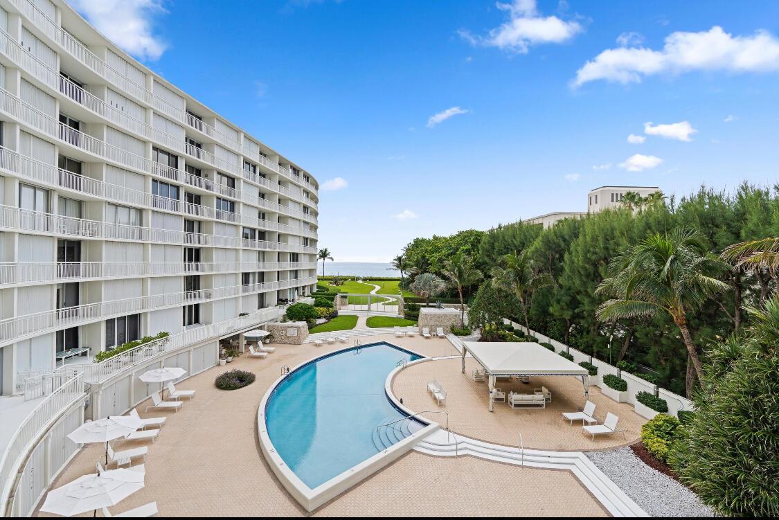 An elevated view of a curved apartment building overlooking a swimming pool and the ocean — 2780 S Ocean Boulevard # 312, Palm Beach FL 33480, PALM BEACH, FL