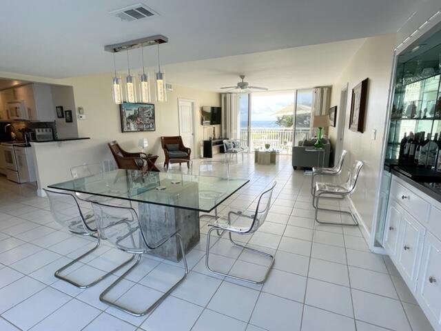 A dining area with a glass table and transparent chairs opens into a bright living room — 2780 S Ocean Boulevard # 312, Palm Beach FL 33480, PALM BEACH, FL
