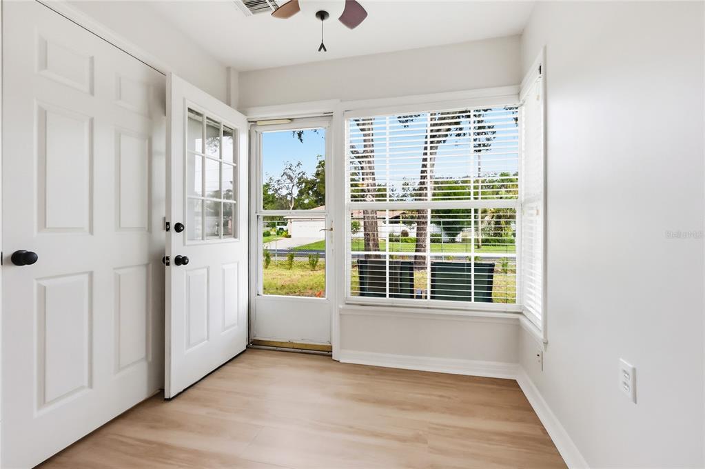 A bright entryway features light wood-look flooring, a white door, and a large window — 249 N HILL AVENUE UNIT 30, DELAND, FL