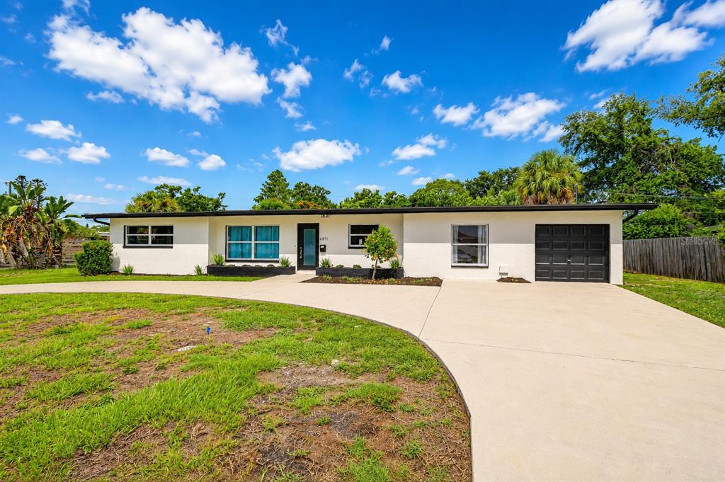 A single-story house with a white exterior, black trim, and a concrete driveway — 6871 4TH STREET S, ST PETERSBURG, FL