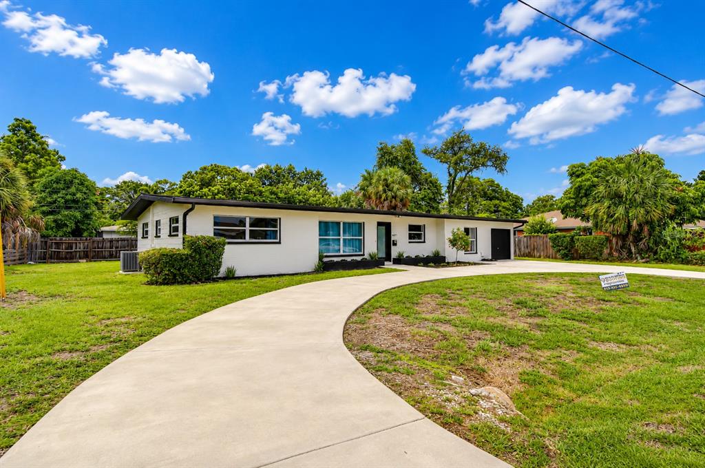 A single-story white house with a black roof and a curved concrete driveway — 6871 4TH STREET S, ST PETERSBURG, FL