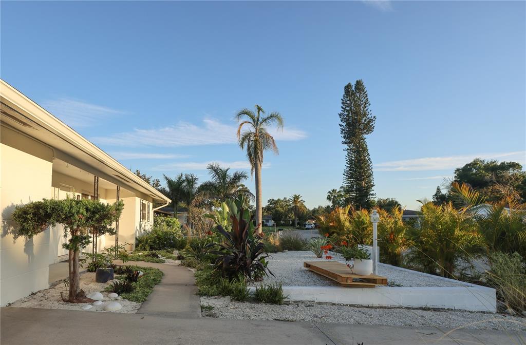 A landscaped front yard with a concrete walkway, white gravel, and various tropical plants — 2513 CROTON AVENUE, SARASOTA, FL