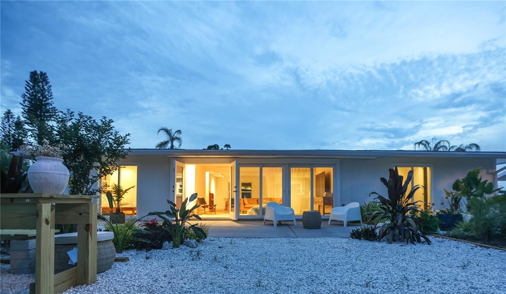 A single-story house with a garage, a concrete driveway, and landscaping under a clear sky — 2513 CROTON AVENUE, SARASOTA, FL