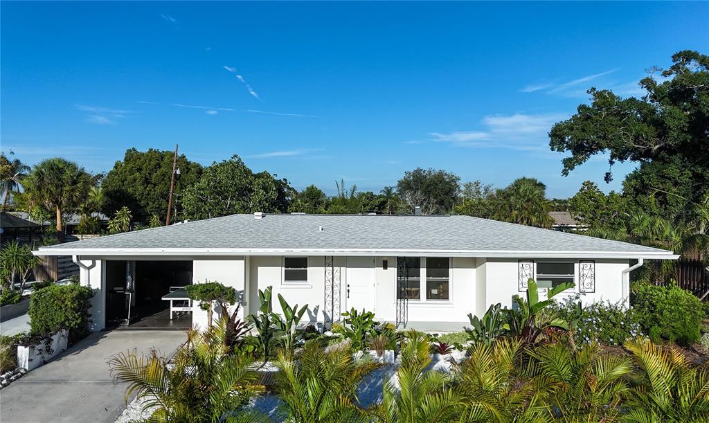 A view of a house exterior at dusk with a patio and gravel yard — 2513 CROTON AVENUE, SARASOTA, FL