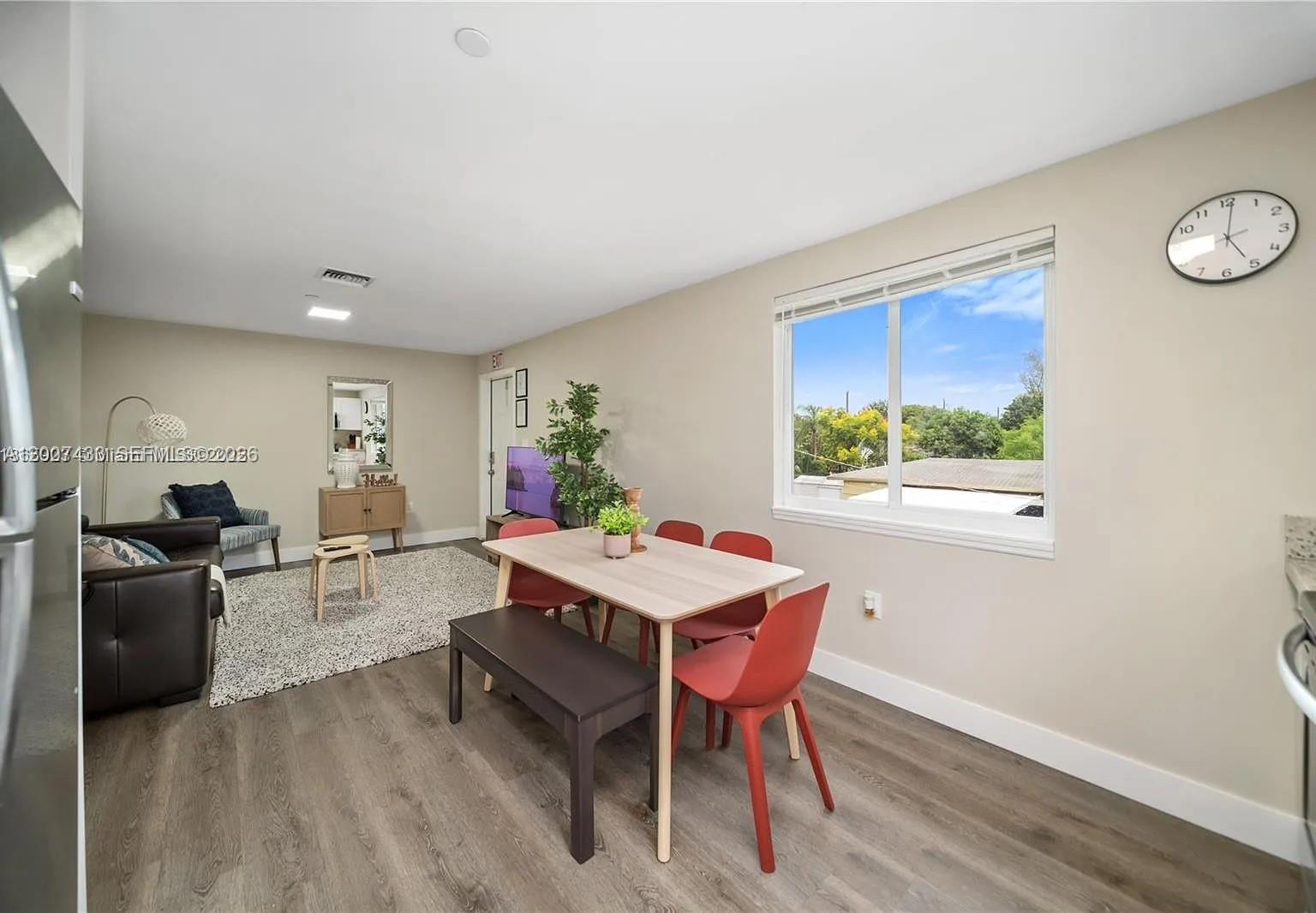 A living and dining area features wood-look flooring, a dining set, and a large window — 2320 Garfield St, Hollywood FL 33020, HOLLYWOOD, FL