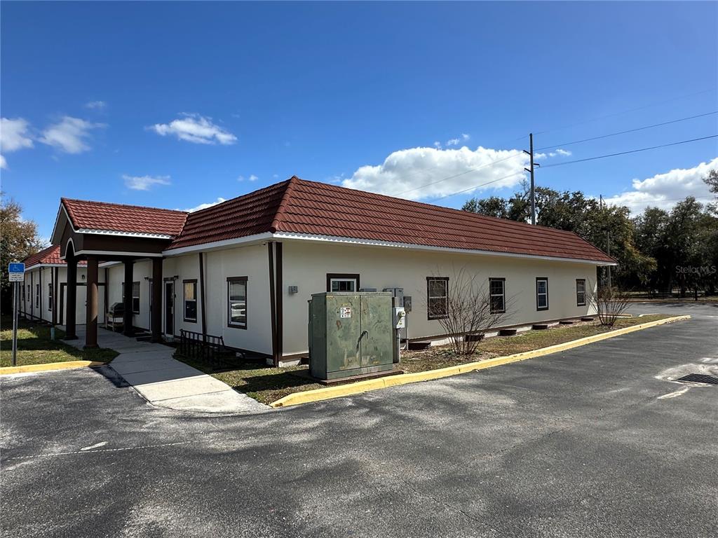 An exterior view of a single-story building with a red tiled roof and parking lot — 401 E NORTH BOULEVARD UNIT 101, LEESBURG, FL