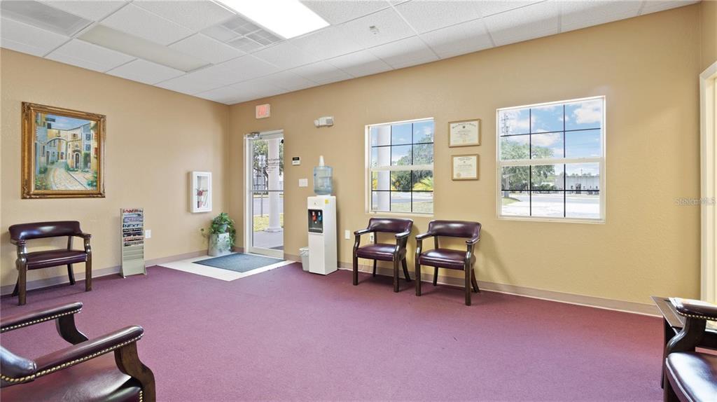 A waiting room with purple carpet, tan walls, several chairs, and a water cooler — 401 E NORTH BOULEVARD UNIT 101, LEESBURG, FL