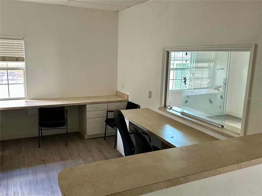 An office room features two built-in desks, a window, and light-colored wood-look flooring — 401 E NORTH BOULEVARD UNIT 101, LEESBURG, FL