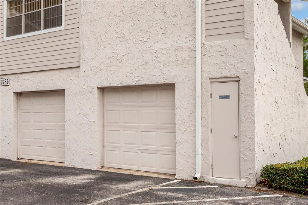 Exterior view of two garage doors and an electrical room door on a stucco building — 2786 CURRY FORD ROAD UNIT 6B, ORLANDO, FL