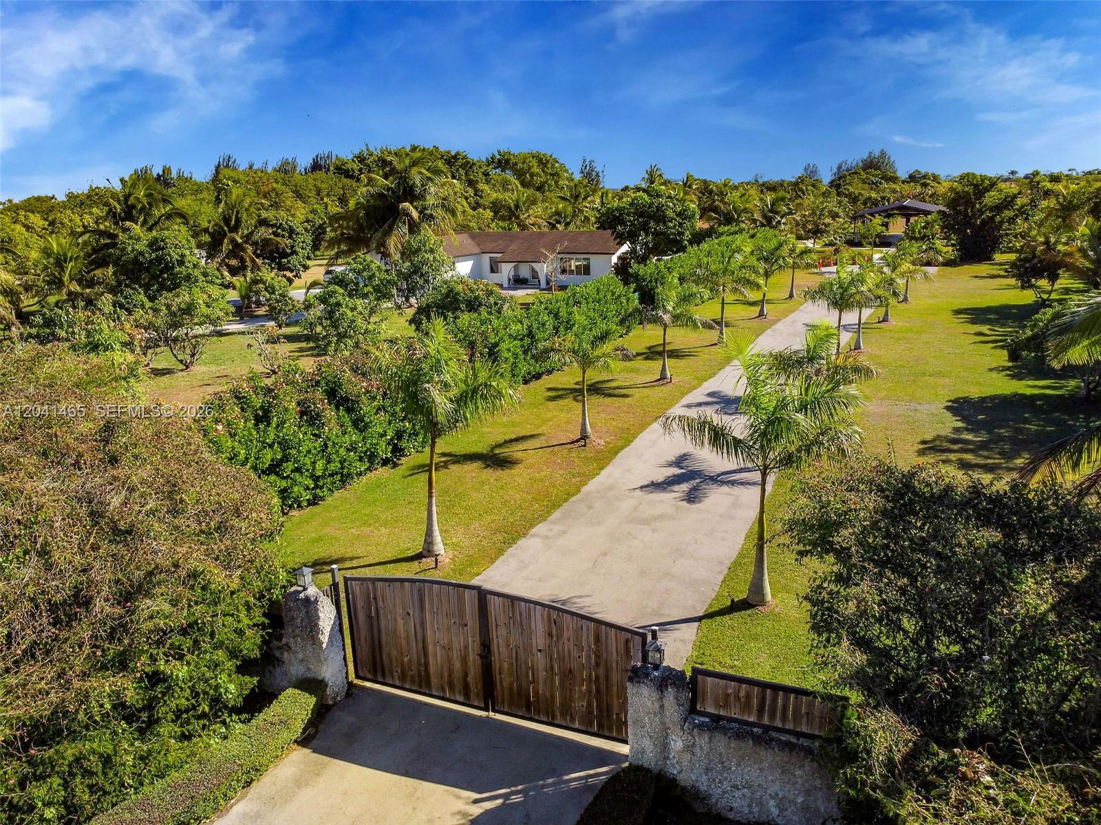 An aerial view shows a long driveway leading to a house behind a wooden gate — 13201 SW 197th Ave, Miami FL 33196, MIAMI, FL