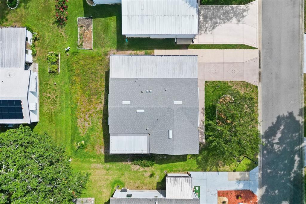 An aerial view shows a residential house with a gray shingled roof and a driveway — 1726 HILTON HEAD BOULEVARD, LADY LAKE, FL