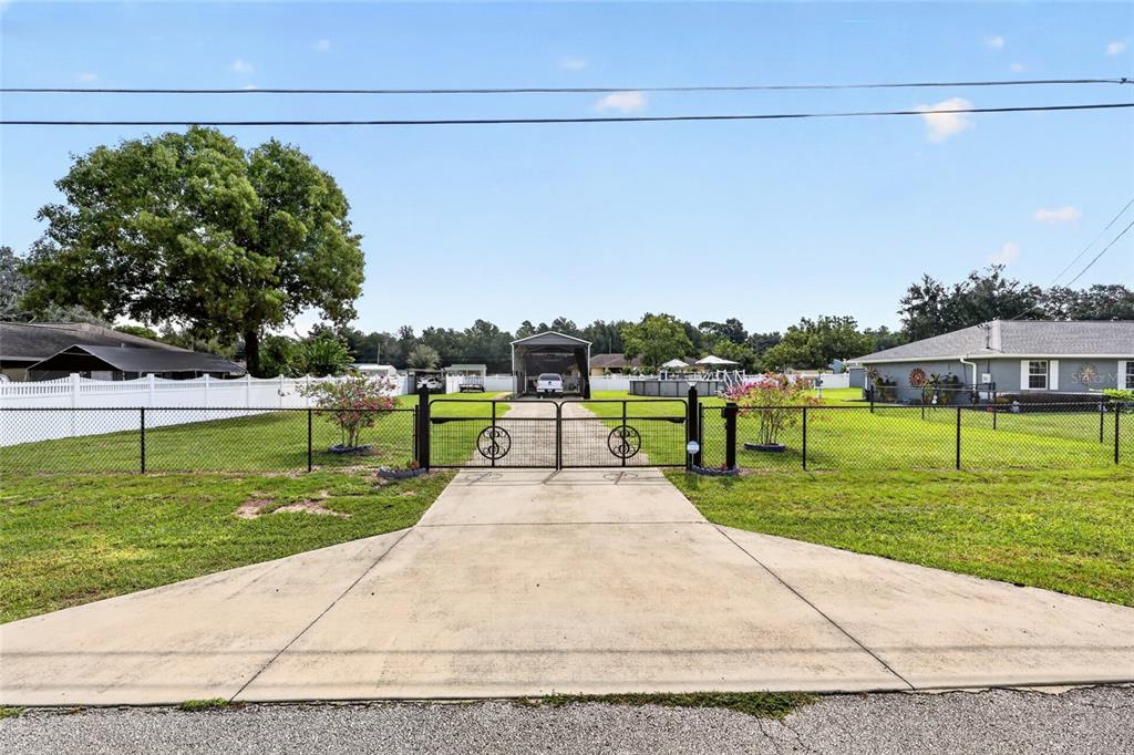 A covered front porch features a gray exterior, a glass-paneled door, and a stone water fountain — 11631 SE 84TH AVENUE, BELLEVIEW, FL