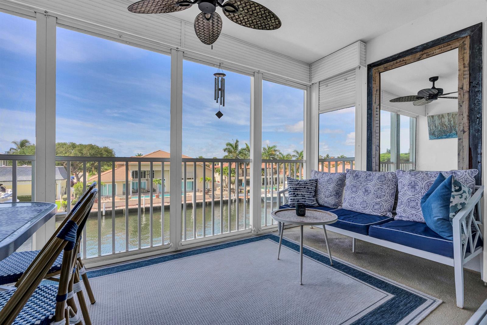 A screened-in porch features a sofa, a small table, and a view of a canal — 3050 NE 48th Court # 305, Lighthouse Point FL 33064, LIGHTHOUSE POINT, FL