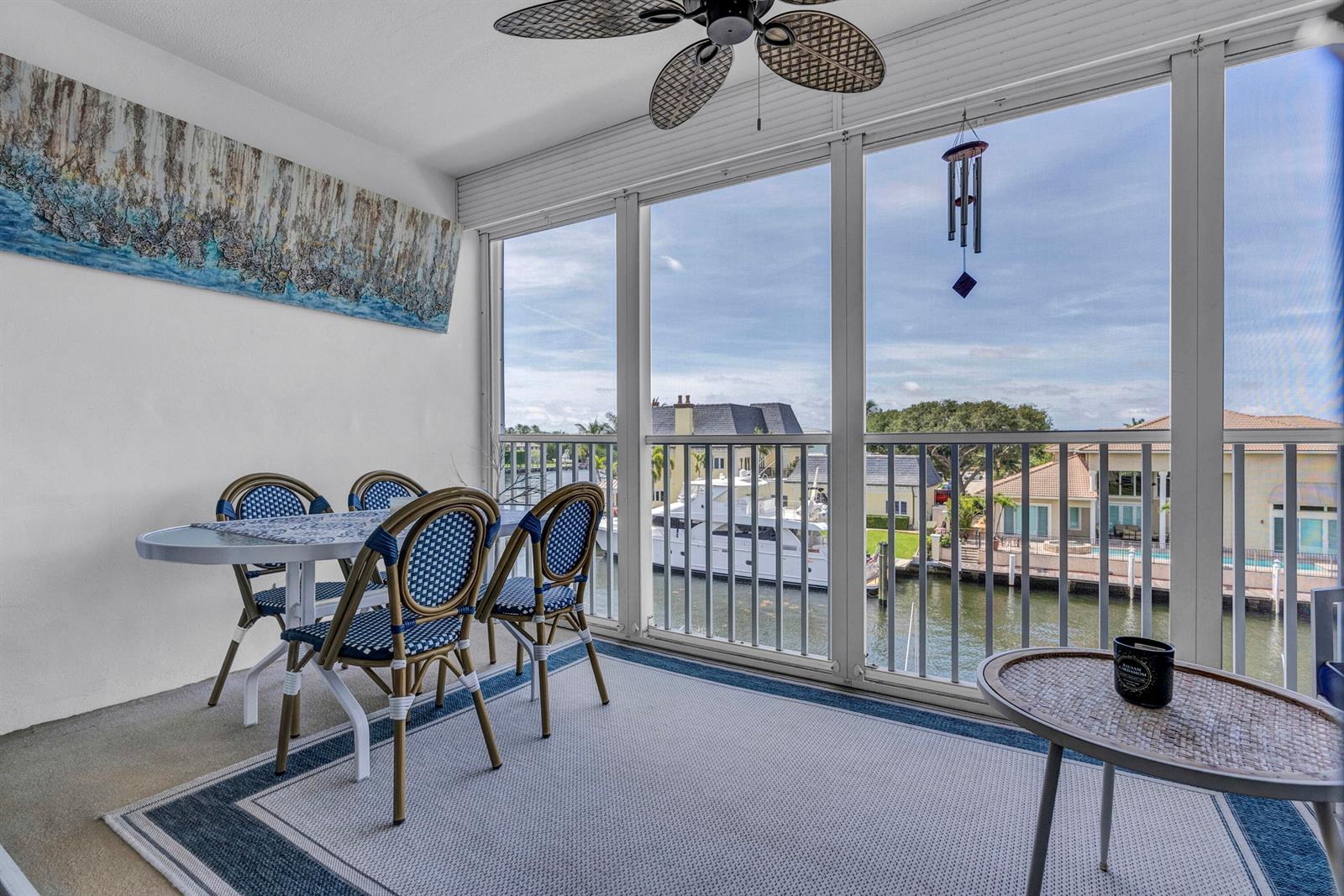 A screened-in balcony features a dining set, a small side table, and water views — 3050 NE 48th Court # 305, Lighthouse Point FL 33064, LIGHTHOUSE POINT, FL