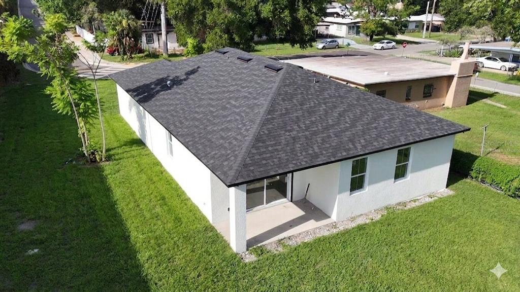An aerial view of a white house with a dark shingled roof and a patio — 601 W MILLER STREET, ORLANDO, FL