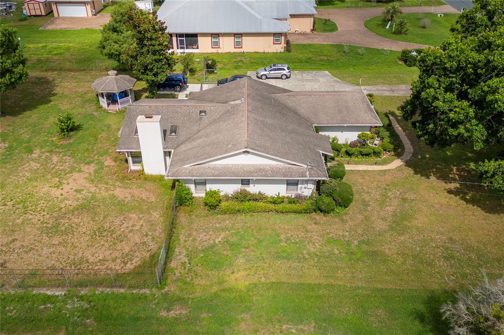 An aerial view shows a single-story house with a shingled roof and a gazebo — 2590 BORINQUEN DRIVE, KISSIMMEE, FL