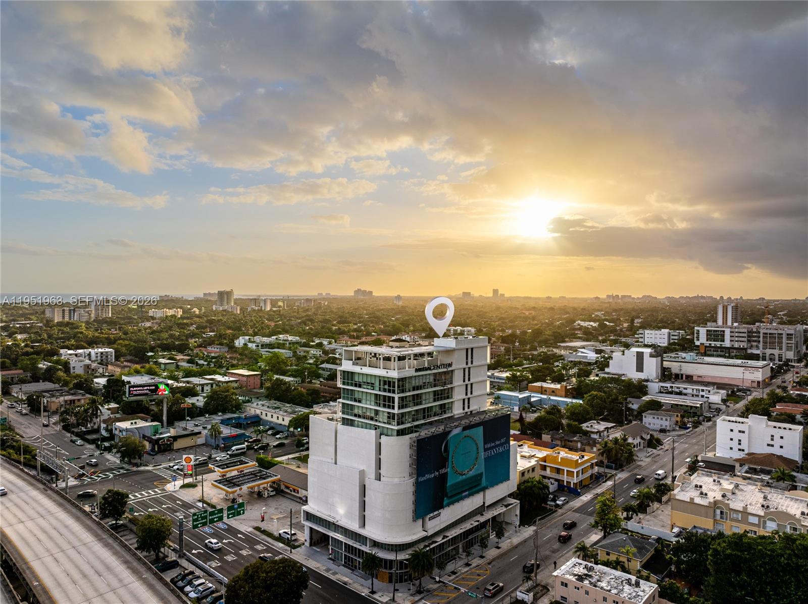 An aerial view shows a multi-story white building with a large billboard in a city — 420 SW 7th St # 1205, Miami FL 33130, MIAMI, FL