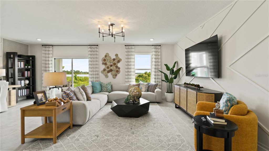 A living room features a sectional sofa, a geometric coffee table, and a wall-mounted television — 2017 STONE WALL COURT, HAINES CITY, FL