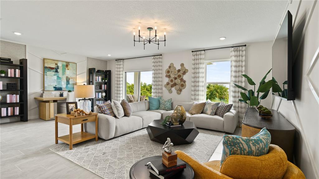 A living room features a sectional sofa, a geometric coffee table, and built-in bookshelves — 2017 STONE WALL COURT, HAINES CITY, FL