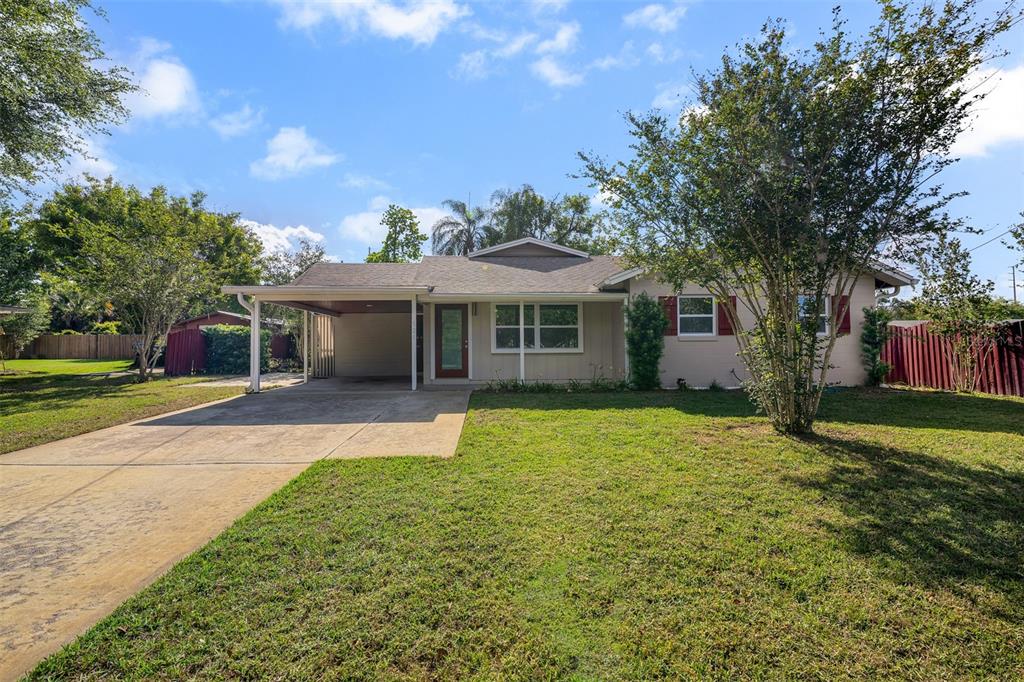 A single-story house with a carport, tan siding, and a front lawn under a blue sky — 525 OLOLU DRIVE, WINTER PARK, FL