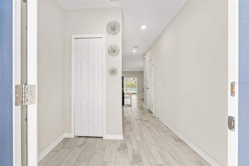 A bright entryway with light-colored tile flooring leads into a hallway with a white closet — 5438 TRIPOLI DRIVE, PALMETTO, FL