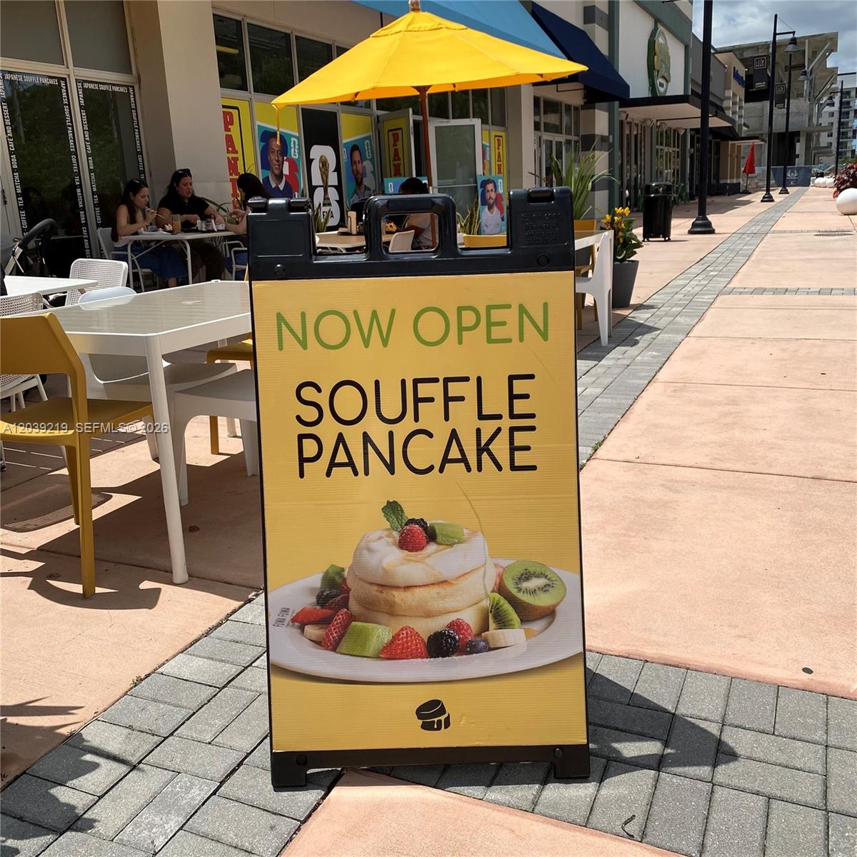 A sidewalk sign for a souffle pancake restaurant sits on a paved outdoor walkway — 5241 NW 87th Ave D104, Doral FL 33178, DORAL, FL