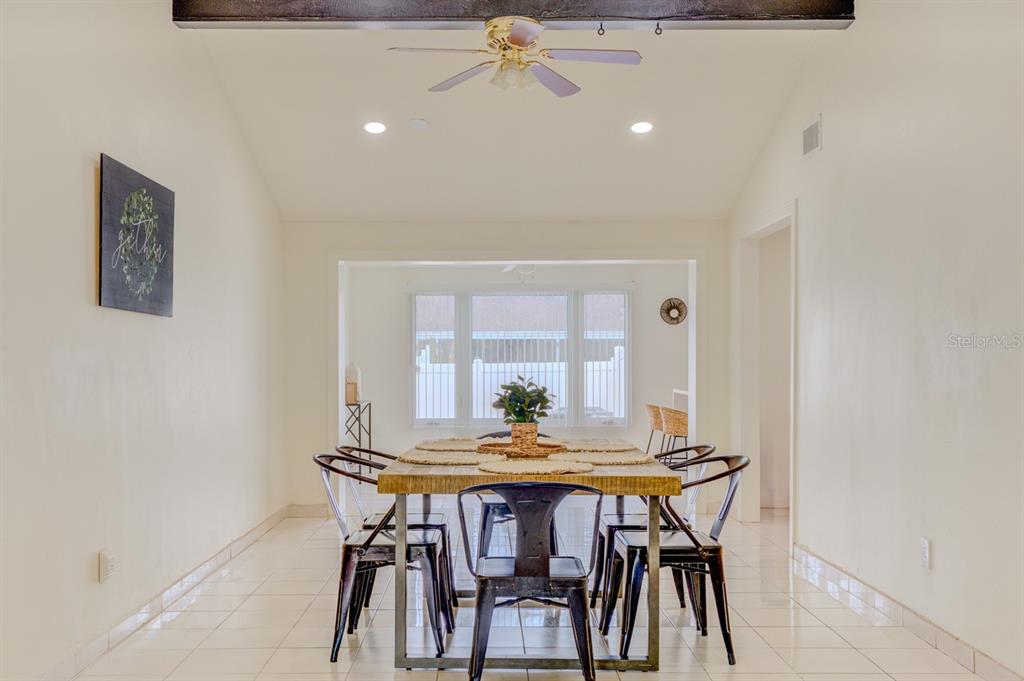 A dining room with a wooden table, metal chairs, tile floors, and a ceiling fan — 8541 BRIAR GROVE CIRCLE, TAMPA, FL