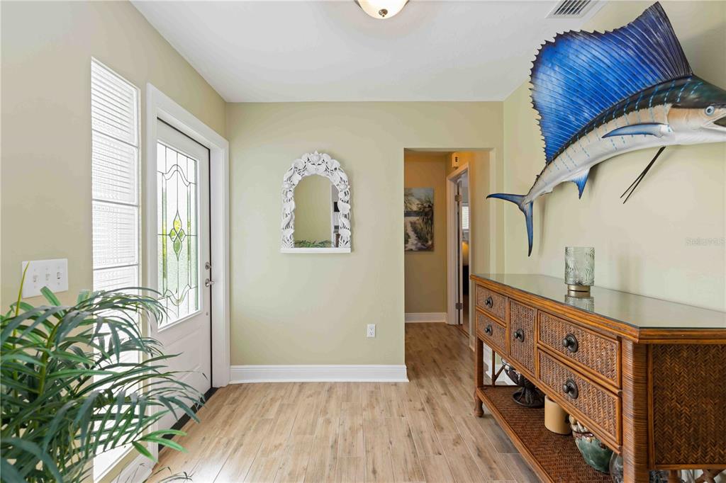 An entryway features light wood-look flooring, a white front door, and a large sailfish wall mount — 7885 MANASOTA KEY ROAD, ENGLEWOOD, FL