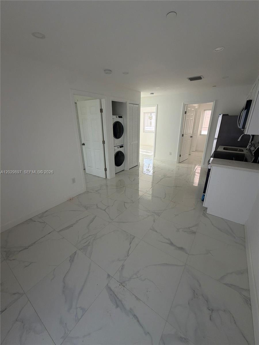 A kitchen area features white cabinets, stainless steel appliances, and white marble-patterned tile flooring — 729 SW 3rd St # 2, Miami FL 33130, MIAMI, FL