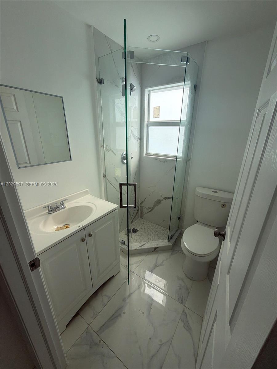 A small bathroom features a white vanity, a glass-enclosed shower, and a toilet — 729 SW 3rd St # 2, Miami FL 33130, MIAMI, FL