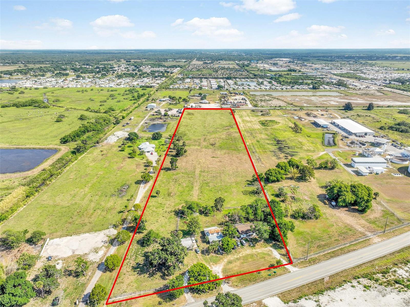 An aerial view shows a large, rectangular plot of land outlined in red near a road — 672 State Road 78, Okeechobee FL 34974, OKEECHOBEE, FL
