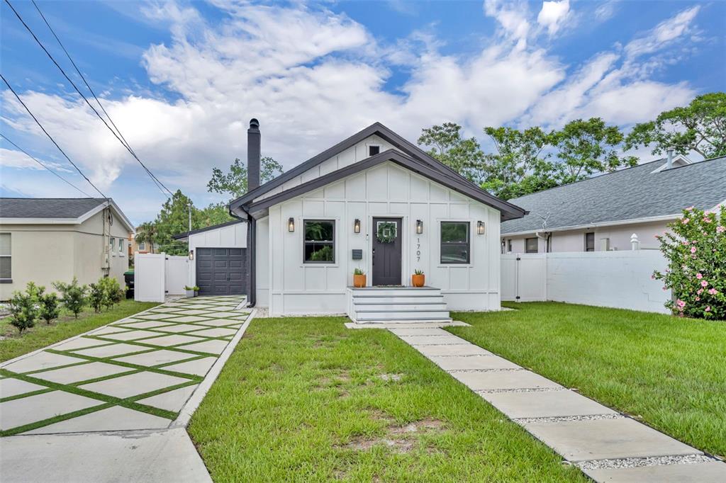 A white house with dark trim features a patterned concrete driveway and a front walkway — 1707 HARMON AVENUE, WINTER PARK, FL