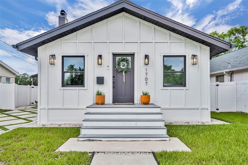 A white house with board and batten siding features a dark gray door and steps — 1707 HARMON AVENUE, WINTER PARK, FL
