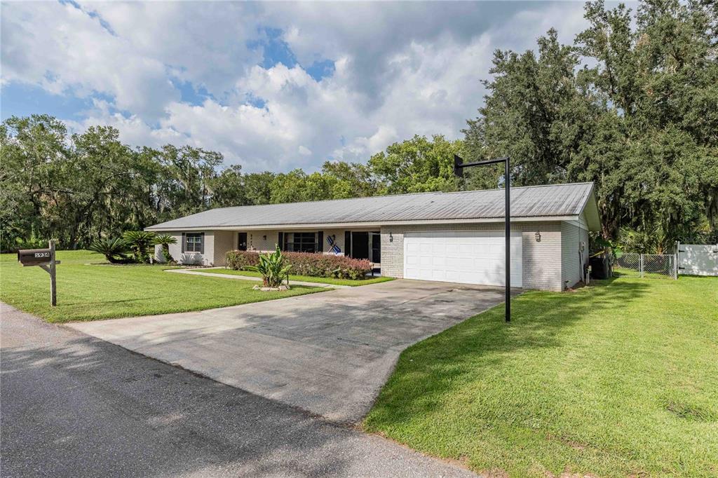 A single-story brick house with a metal roof and an attached two-car garage — 5934 RIDGE DRIVE, LAKELAND, FL