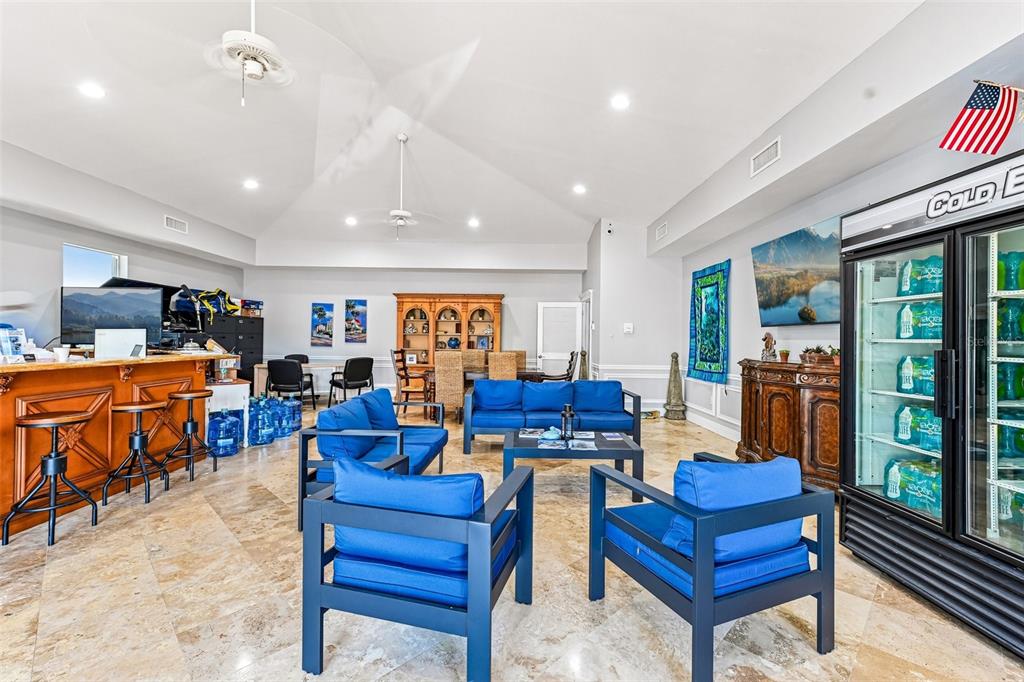 A large room features a bar, blue seating, a commercial refrigerator, and tile flooring — 103950 OVERSEAS HIGHWAY UNIT RU62, KEY LARGO, FL