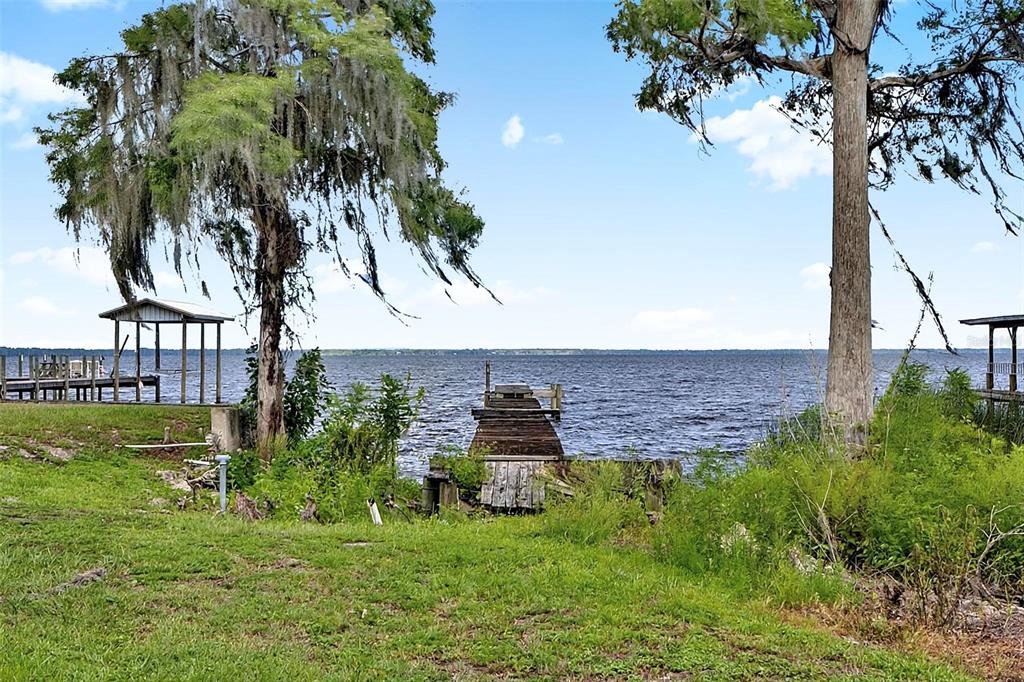 A living room features wood-paneled walls, a built-in bar, and a carpeted floor — 311 POMONA LANDING ROAD, CRESCENT CITY, FL