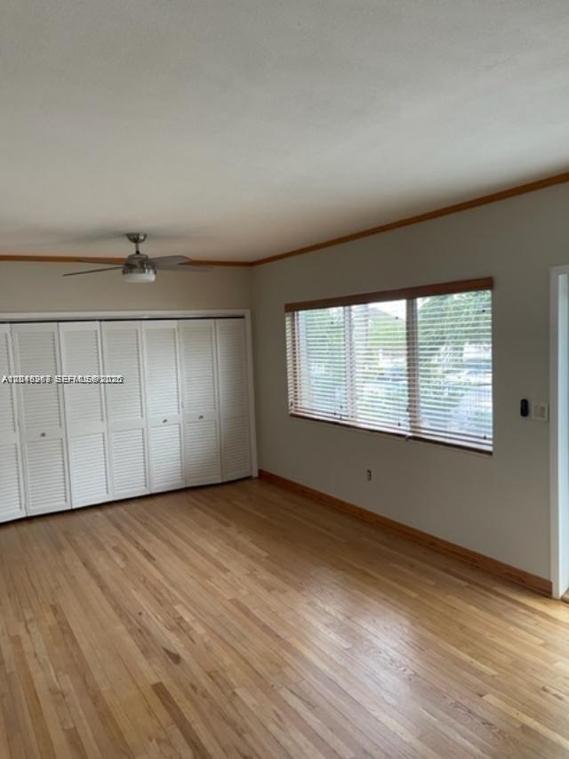 A room with light wood flooring, white louvered closet doors, and a window with blinds — 1140 Venetian Way # 2C, Miami FL 33139, MIAMI, FL