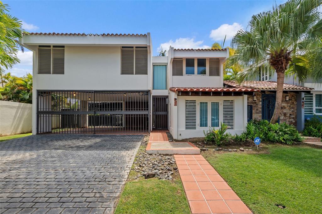 A two-story house with a gated carport, tiled walkway, and a stone-accented entryway — 2 CALLE 2 UNIT C5, SAN JUAN, PR