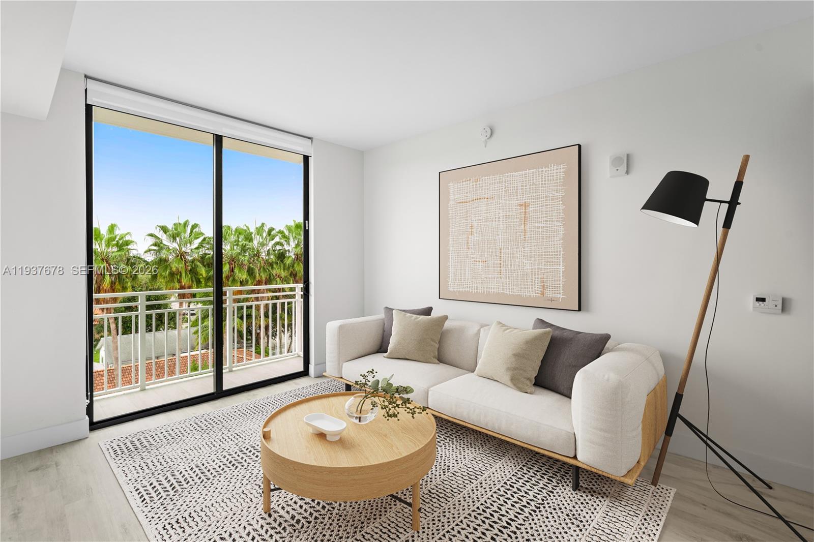 A modern living room features a sofa, round coffee table, and a balcony with palm trees — 1601 SW 32 Avenue # 514, Miami FL 33145, MIAMI, FL
