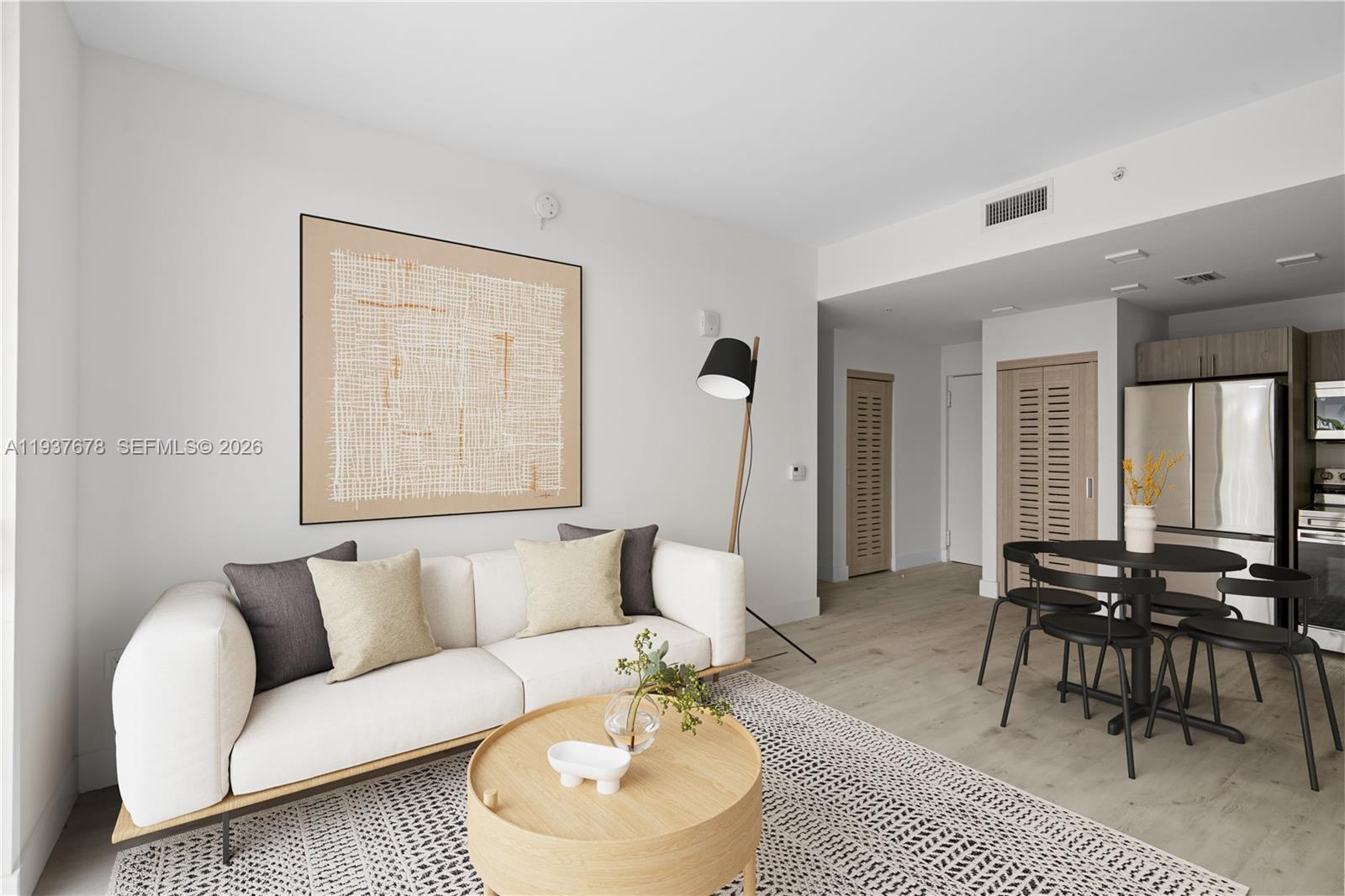 A modern living room and dining area feature a white sofa, round table, and light flooring — 1601 SW 32 Avenue # 514, Miami FL 33145, MIAMI, FL