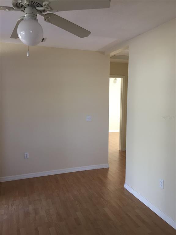 A room with light-colored walls, wood-look flooring, and a ceiling fan with a light fixture — 2417 GOLFVIEW STREET, LAKELAND, FL
