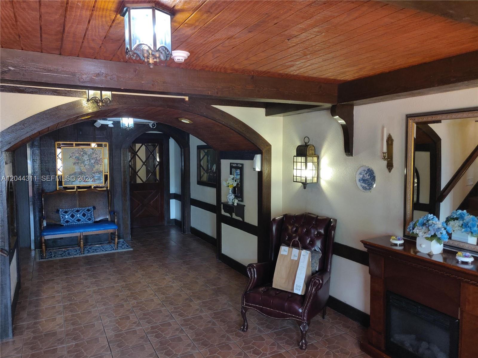 An interior view of a room with wood-paneled ceilings, arched beams, and tiled flooring — 3750 Inverrary Dr # 2Q, Lauderhill FL 33319, LAUDERHILL, FL