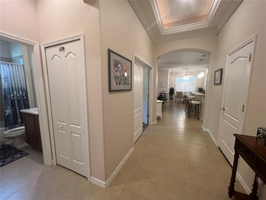 A hallway with tile flooring leads toward an open kitchen and dining area — 1829 KNIGHTS BRIDGE TRAIL, PORT CHARLOTTE, FL