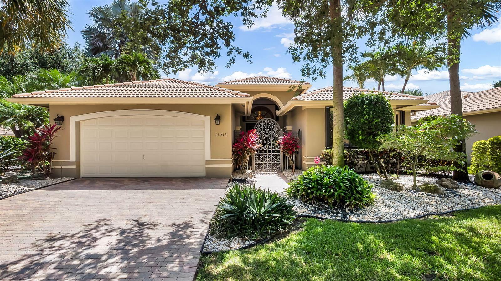 A single-story house with a beige exterior, tile roof, and a paved driveway — 11012 Vía Sorrento, Boynton Beach FL 33437, BOYNTON BEACH, FL