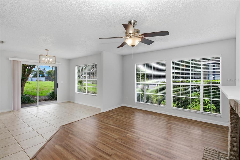 A living and dining area with wood-look flooring, tile, a ceiling fan, and sliding glass doors — 939 FRAMLINGHAM COURT UNIT 103, LAKE MARY, FL