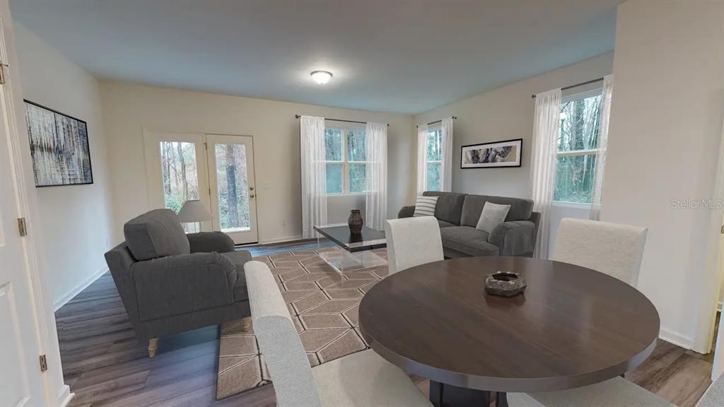 A living and dining area features gray furniture, a round table, and wood-look flooring — 14876 LUCCA WAY, DADE CITY, FL