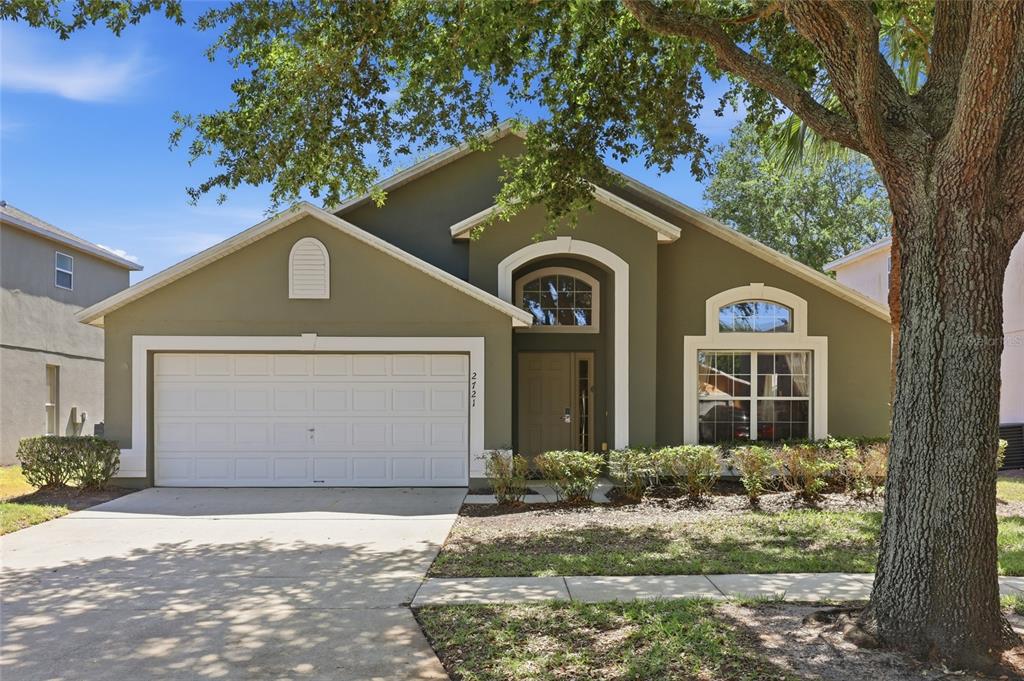A single-story house with a green exterior, a two-car garage, and an arched entryway — 2721 LIDO KEY DRIVE, KISSIMMEE, FL