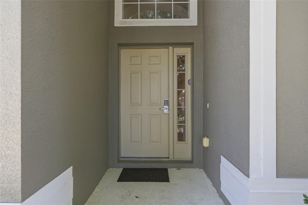A beige front door with a side window and a transom window above — 2721 LIDO KEY DRIVE, KISSIMMEE, FL