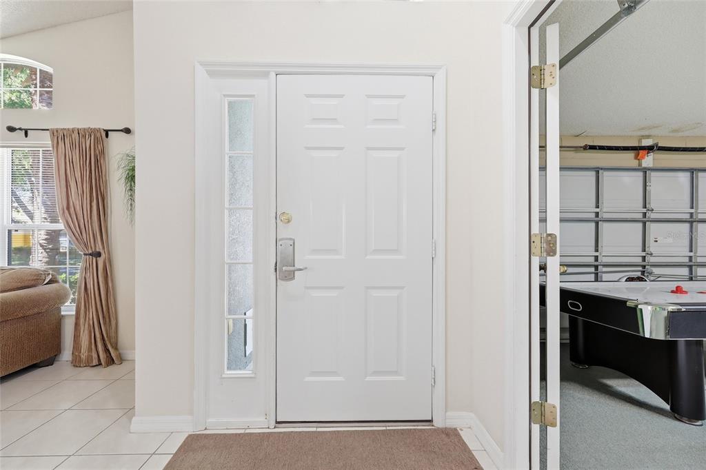 A white front door with a side window opens into a room with a game table — 2721 LIDO KEY DRIVE, KISSIMMEE, FL
